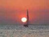 Baia Verde fraction of Gallipoli (Lecce, Italy): Sunset with lighthouse and sailing boat